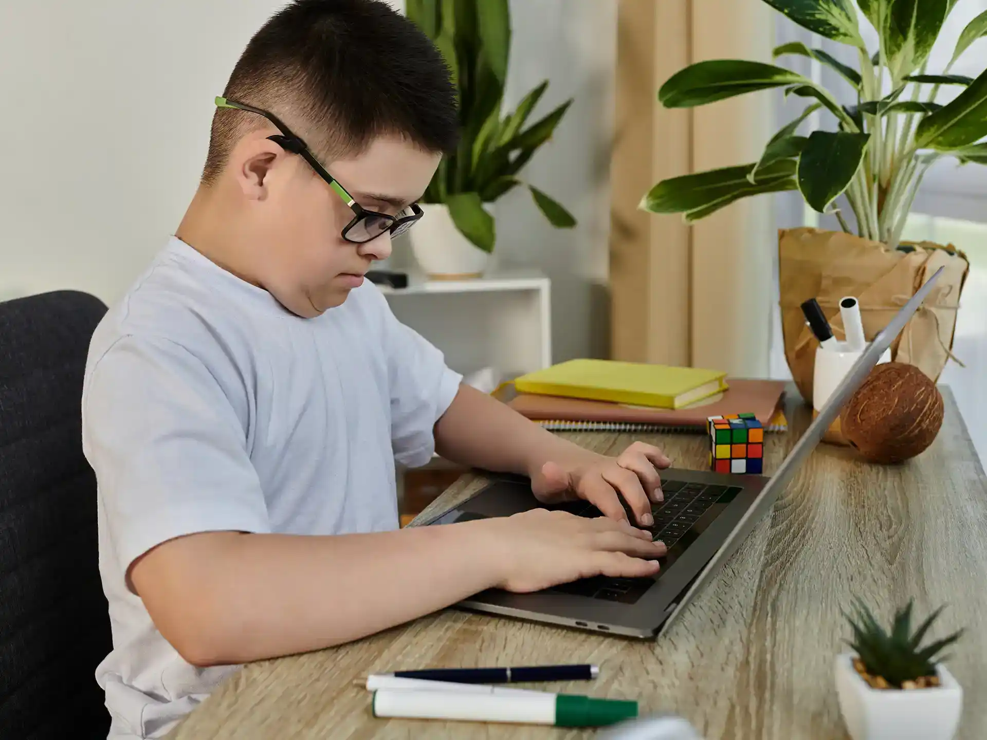 Young boy with down syndrome focuses on laptop